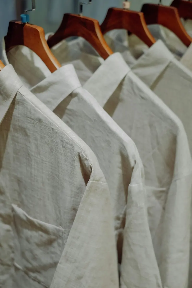 Camisas de lino planchadas en ganchos de madera